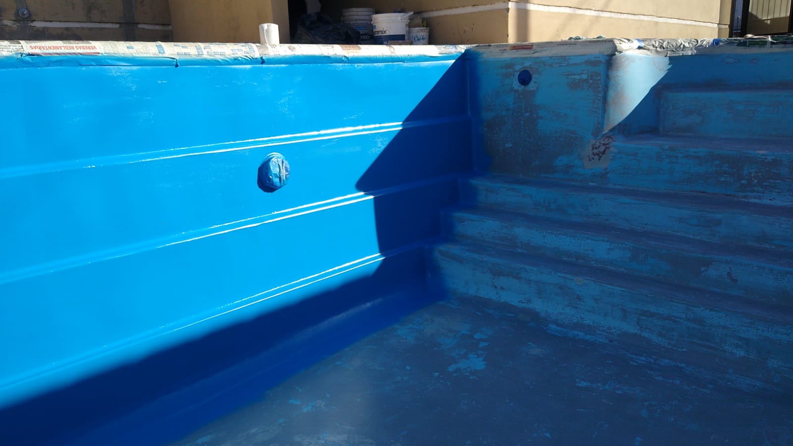 Pileta residencial en proceso de pintura azul